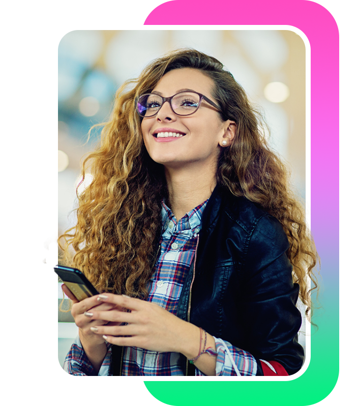 A woman holding her phone and smiling