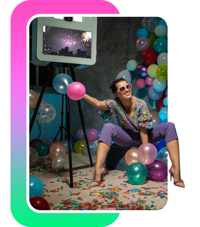 A woman sitting by a photo booth camera