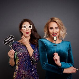 Two women having fun with photo booth props.