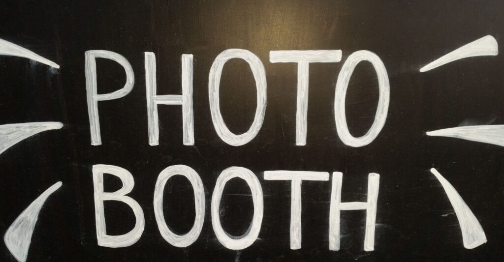 Hand-drawn "Photo Booth" sign on a chalkboard