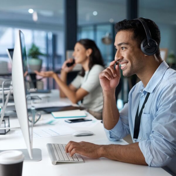 Man providing customer support while smiling at a desk